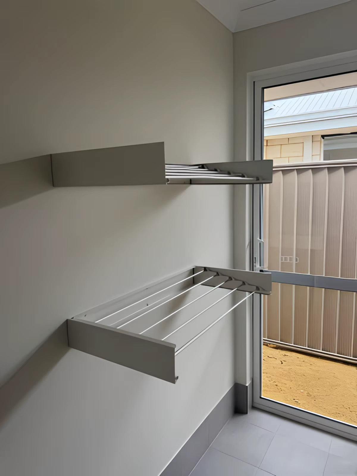 Wall-mounted foldable drying rack in use in a well-organised utility room
